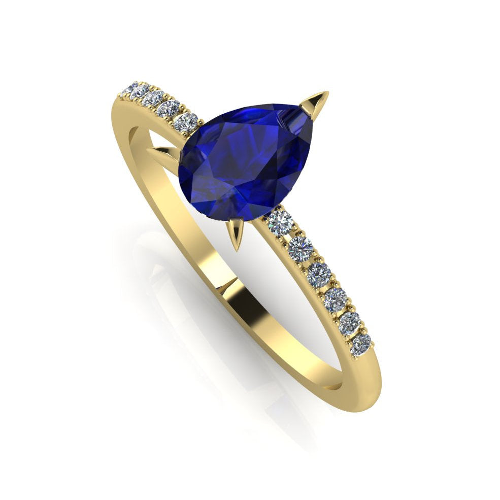 Front three-quarter studio view of the Calista sapphire ring, highlighting the row of brilliant white pavé diamonds set into the warm, rich yellow gold shoulders.