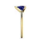 Side profile product photo of the Calista ring, displaying the clean, secure three-prong claw basket setting holding the pear-cut blue sapphire.