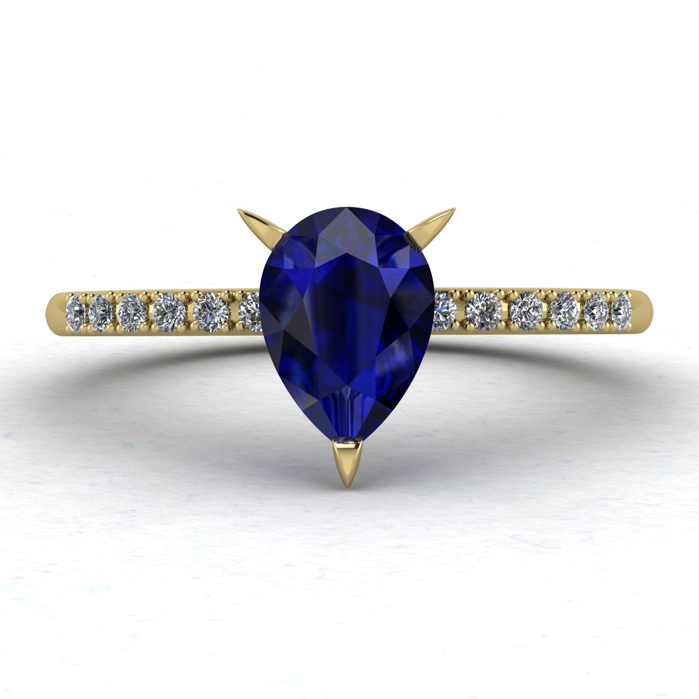 Calista engagement ring, showcasing a prominent pear-shaped blue sapphire on a polished yellow gold band with diamond shoulders.