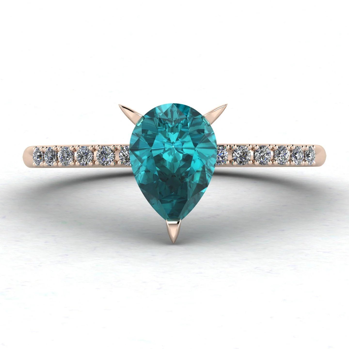 Top-down studio hero shot of the Calista 18ct rose gold ring, featuring a rich pear-shaped teal sapphire and diamonds.