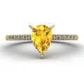 Calista engagement ring in 18ct yellow gold, capturing the vibrant sun-drenched sparkle of the pear-shaped yellow sapphire and surrounding diamonds.