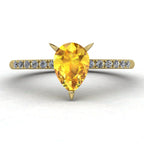 Calista engagement ring in 18ct yellow gold, capturing the vibrant sun-drenched sparkle of the pear-shaped yellow sapphire and surrounding diamonds.