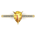Top view of the yellow gold Calista ring, showcasing the raised basket setting for the pear sapphire and the diamond-set shoulders.