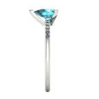 Calista pear shaped teal sapphire and diamond engagement ring in 18ct white gold, side profile showing the elegant setting and diamond shoulders, handmade in our London studio