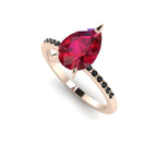 High angle studio detail shot of the Calista alternative bridal ring, showing the deep red tones of the ruby facets against the dark shoulder stones.