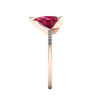 Side profile product photo of the Calista ring, displaying the elegant three-prong basket setting holding the pear-cut ruby.