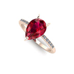 High angle studio detail shot of the Calista bridal ring, showing the deep red clarity through the facets of the pear ruby and the delicate diamond shoulders.