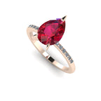 Front three-quarter studio view of the Calista ruby ring, highlighting the brilliant white diamonds pavé-set into the warm rose gold shoulders.