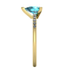 Side profile product photo of the yellow gold Calista ring, highlighting the elegant raised basket setting for the pear sapphire.