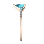 Side profile product photo of the rose gold Calista ring, highlighting the elegant raised basket setting for the pear sapphire.