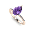 Front three-quarter studio view of the Calista violet sapphire ring, showcasing the brilliant white diamonds pavé-set into the rose gold shoulders.