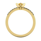 Front view of the yellow gold Calista ring, showcasing the raised basket setting for the pear sapphire and the diamond-set shoulders.