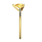 Side profile view of the yellow gold Calista ring, showcasing the raised basket setting for the pear sapphire and the diamond-set shoulders.