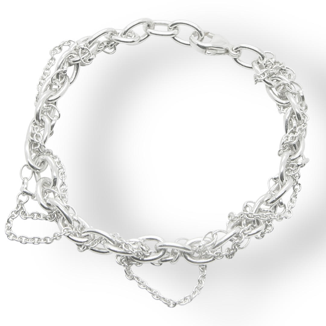 Flat lay view of a heavyweight sterling silver multi-strand bracelet featuring various interconnected chain styles