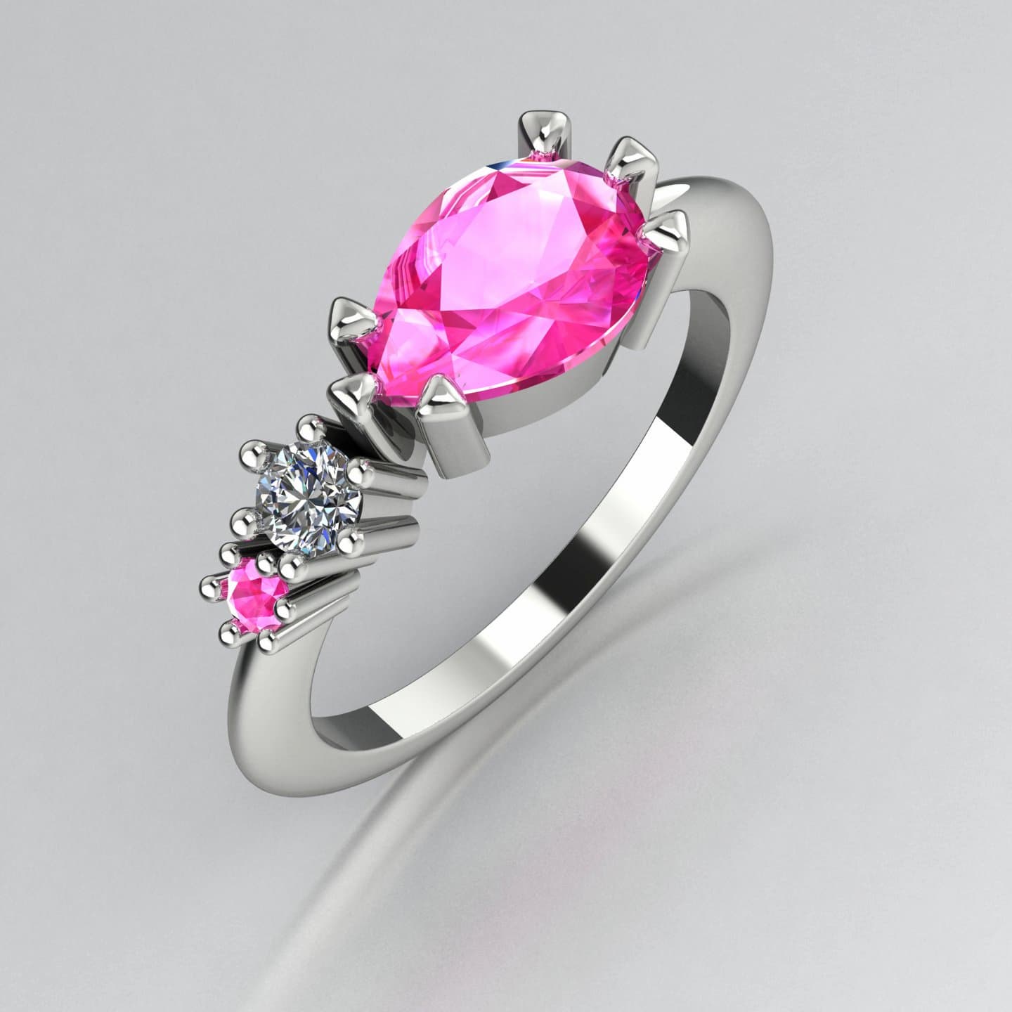 Asymmetrical Comet engagement ring in 18ct white gold with a pear shaped pink sapphire, round diamond and round pink sapphire accent stones, handmade in our London studio