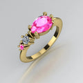 Angled view of the Comet yellow gold ring with a pear-shaped pink sapphire, round white diamond and smaller pink sapphire along one shoulder