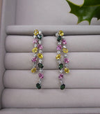 lifestyle view of the double-drop earrings, highlighting the sparkle of the diamonds and gemstones on velvet tray.
