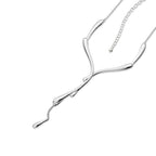 Dripping Silver Necklace on white background — sculptural sterling silver lariat with fluid drip bar and cascading droplet pendant