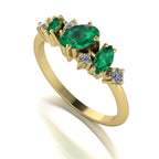 An angled perspective of the Atlantis Paradise ring highlighting the asymmetrical arrangement of emeralds and diamonds.