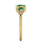 Side profile of the 18ct yellow gold emerald ring showing the multi-level settings and sculptural design.