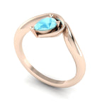 Enchanted aquamarine pear engagement ring in rose gold, three-quarter angle view showing vivid blue stone nestled in asymmetric setting