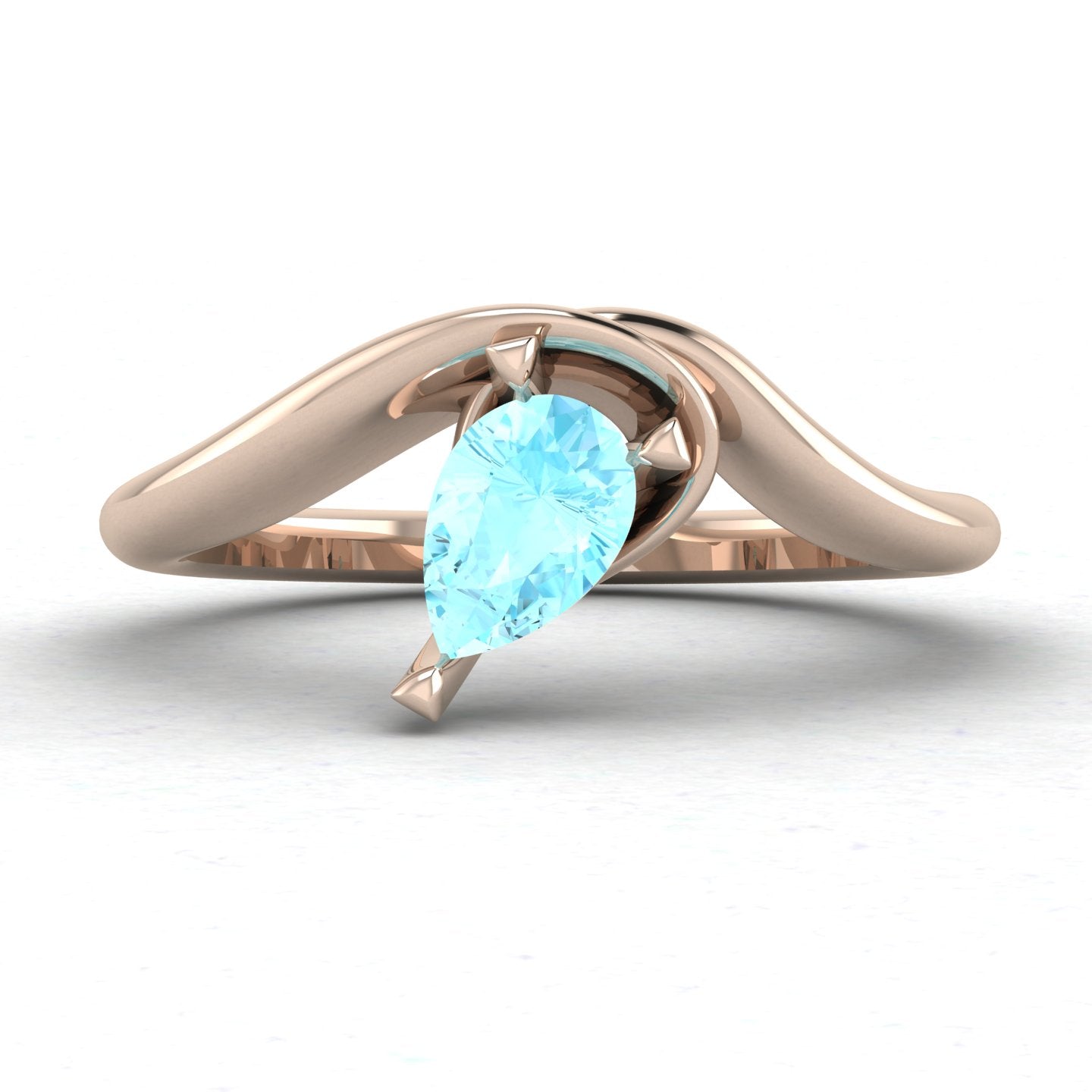 Enchanted pear shaped aquamarine asymmetric solitaire engagement ring in rose gold, front view showing icy blue stone and sculptural sweeping band