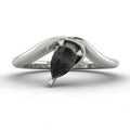 Enchanted pear shaped black diamond asymmetric solitaire engagement ring in white gold, front view showing sculptural sweeping band