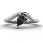 Enchanted pear shaped black diamond asymmetric solitaire engagement ring in white gold, front view showing sculptural sweeping band