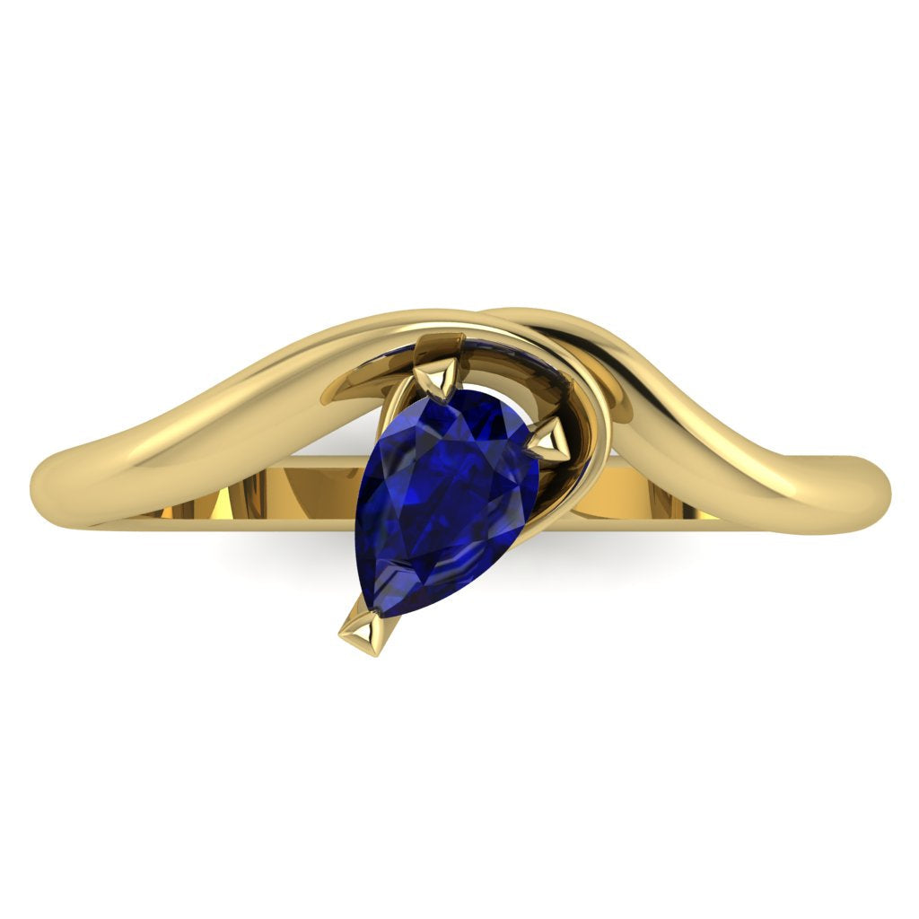 Enchanted pear shaped blue sapphire ring in yellow gold, overhead top-down view showing deep blue stone and fluid asymmetric band design