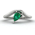 Enchanted pear shaped emerald asymmetric engagement ring in white gold, front view showing sculptural sweeping band