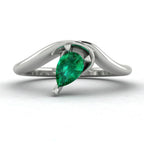 Enchanted pear shaped emerald asymmetric engagement ring in white gold, front view showing sculptural sweeping band