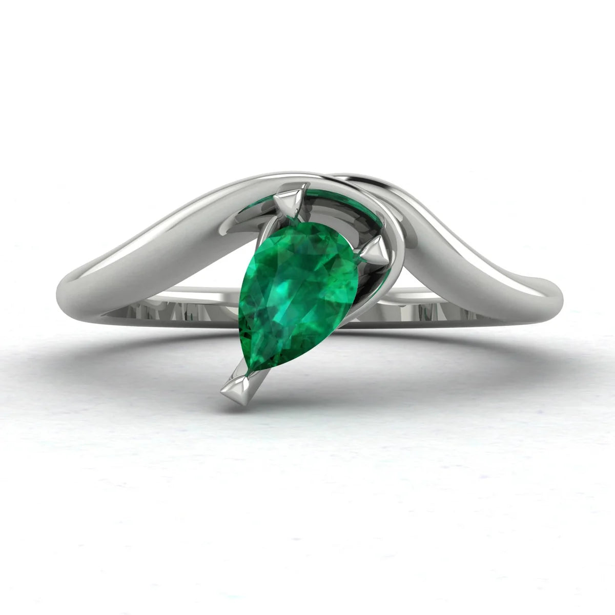 Enchanted pear shaped emerald asymmetric engagement ring in white gold, front view showing sculptural sweeping band