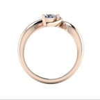 Enchanted pear shaped lab grown diamond asymmetric solitaire engagement ring in rose gold, through finger view showing brilliant diamond and sculptural sweeping band
