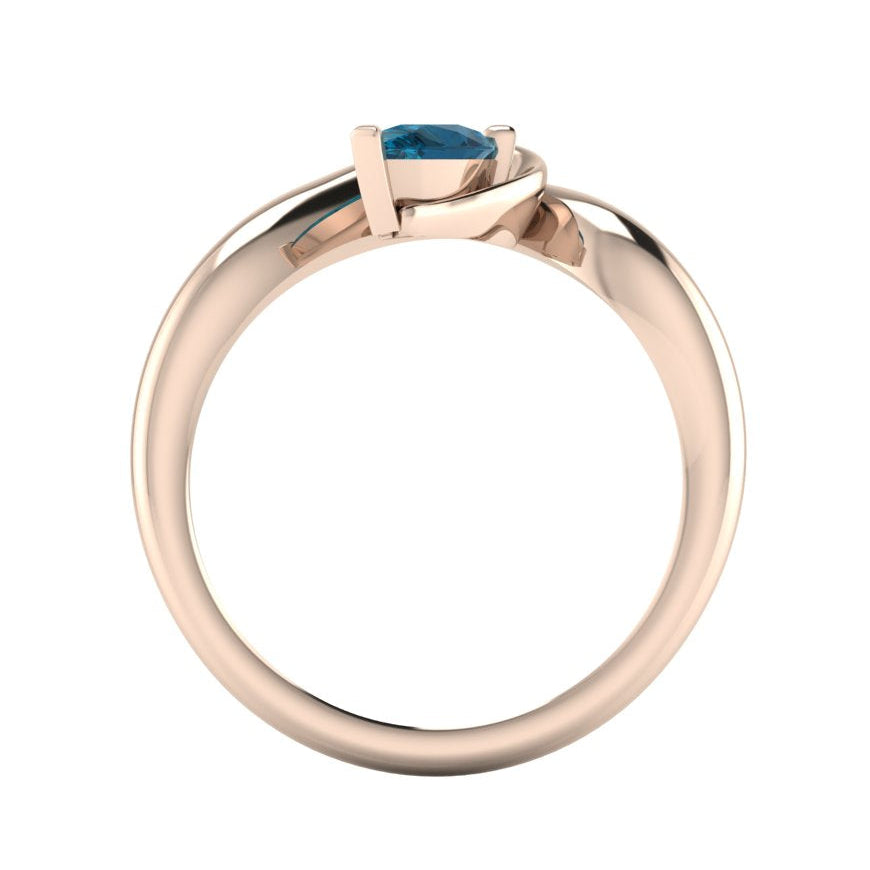 Enchanted London Blue Topaz ring in rose gold, straight-on through-finger view showing clean band interior and low-set asymmetric profile
