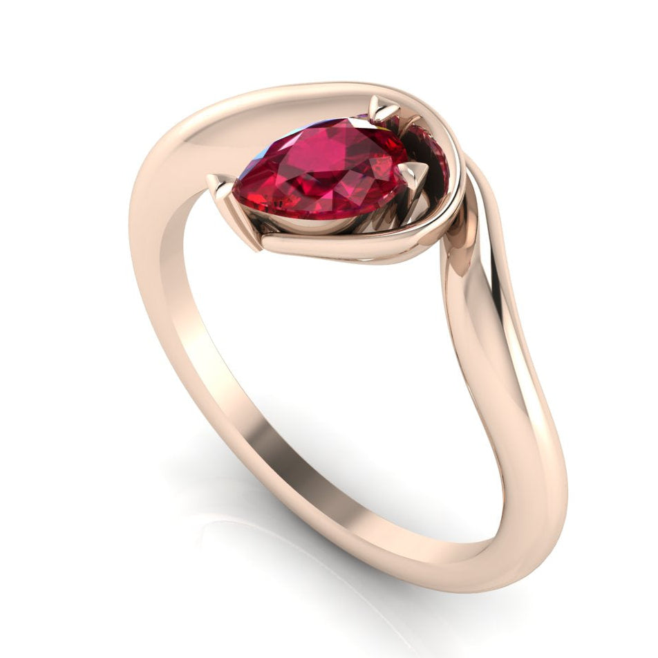 Enchanted pear ruby engagement ring in rose gold, three-quarter angle view showing vivid red stone and fluid asymmetric wrapped setting