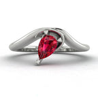 Enchanted pear shaped ruby asymmetric solitaire engagement ring in white gold, front view showing vivid red ruby and sculptural sweeping band