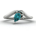 Enchanted pear shaped teal sapphire asymmetric solitaire ring in white gold, front view showing sculptural sweeping band