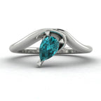 Enchanted pear shaped teal sapphire asymmetric solitaire ring in white gold, front view showing sculptural sweeping band