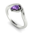 Enchanted pear violet sapphire engagement ring in white gold, three-quarter angle view showing delicate lavender stone nestled in wrapped asymmetric setting