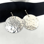 Silver round earrings on a black ribbon with a white background