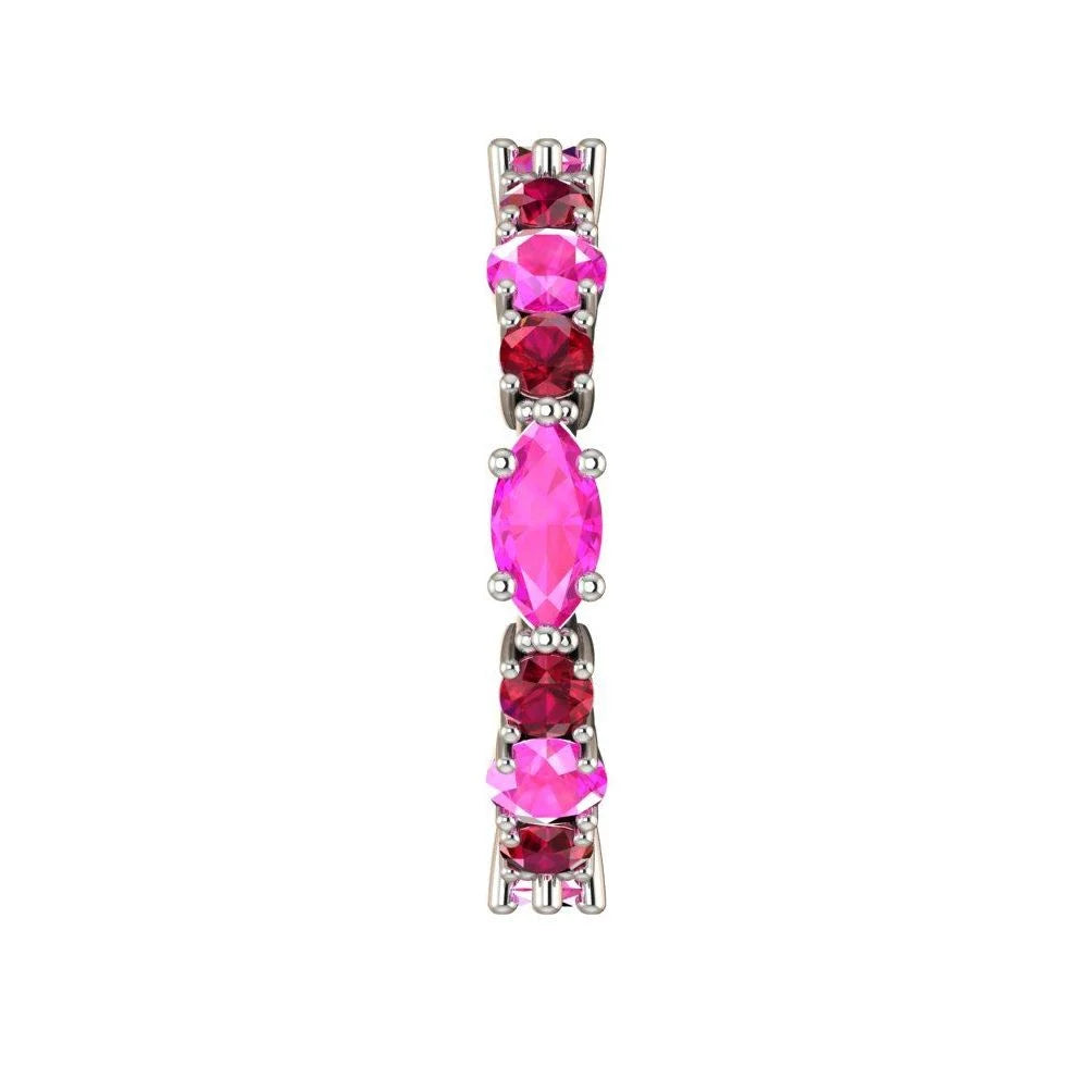 Macro detail of the Fire ring showcasing the vibrant red rubies and pink sapphires in a polished white metal setting.