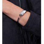 Flat Drip Silver Bangle in sterling silver — model wearing cuff on wrist against dark jacket, showing the bold domed front