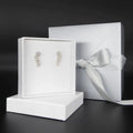 Fleur cascading flower earrings in recycled sterling silver displayed with white jewellery packaging