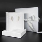 Fleur cascading flower earrings in recycled sterling silver displayed with white jewellery packaging