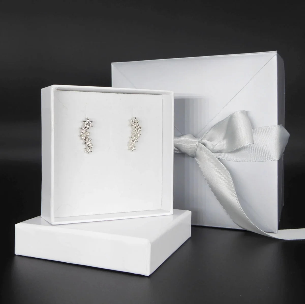Fleur cascading flower earrings in recycled sterling silver displayed with white jewellery packaging