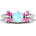 Flutterby aquamarine and pink sapphire butterfly ring front view — ice-blue aquamarine centre with four marquise pink sapphire wings in recycled 18ct white gold by Nude Jewellery