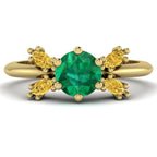 Flutterby emerald and yellow diamond butterfly engagement ring front view — round emerald centre with four marquise yellow diamond wings in recycled 18ct yellow gold by Nude Jewelley