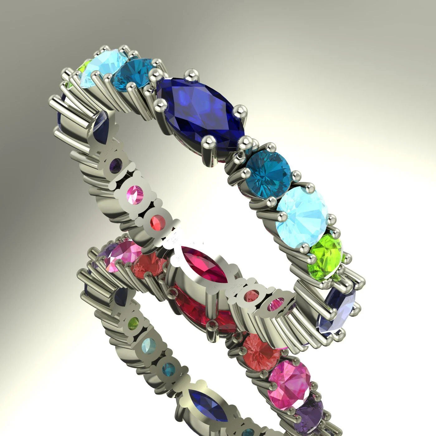 An angled profile view of the Allsorts eternity ring featuring a mix of blue sapphires, red rubies, and pale aquamarines.