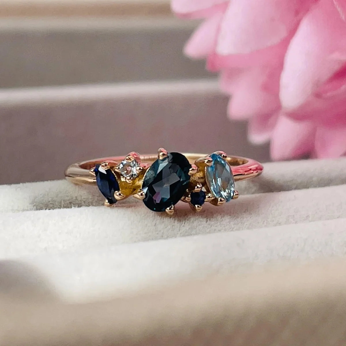 Atlantis London blue topaz and sapphire asymmetrical engagement ring in 18ct rose gold, front view showing the deep blue gemstones and warm rose gold setting, handmade in our London studio