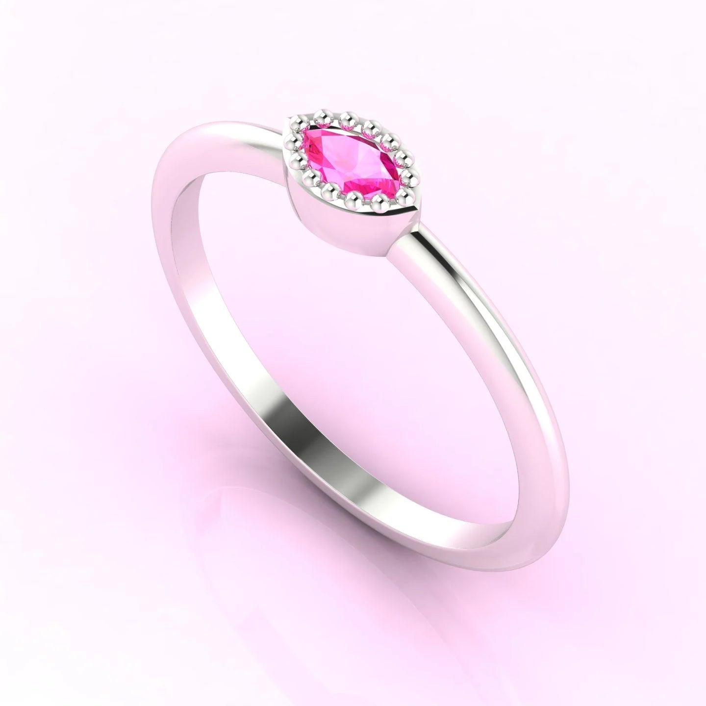 Three-quarter view of a handmade marquise pink sapphire ring showing the delicate beaded setting.